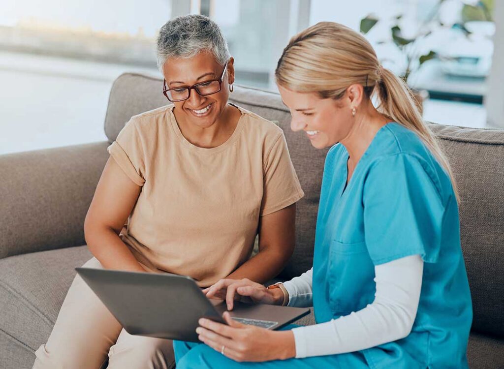 Two older adults review paperwork with a family member at a kitchen table, discussing documents and notes together.