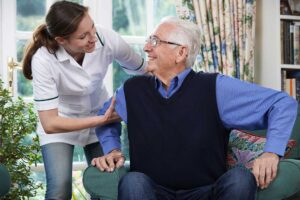 Older adult and family member reviewing healthcare documents at a kitchen table