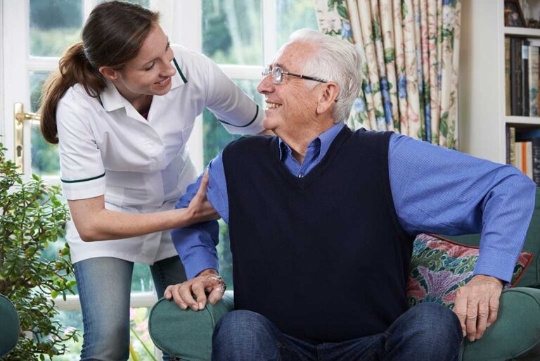 Older adult and family member reviewing healthcare documents at a kitchen table